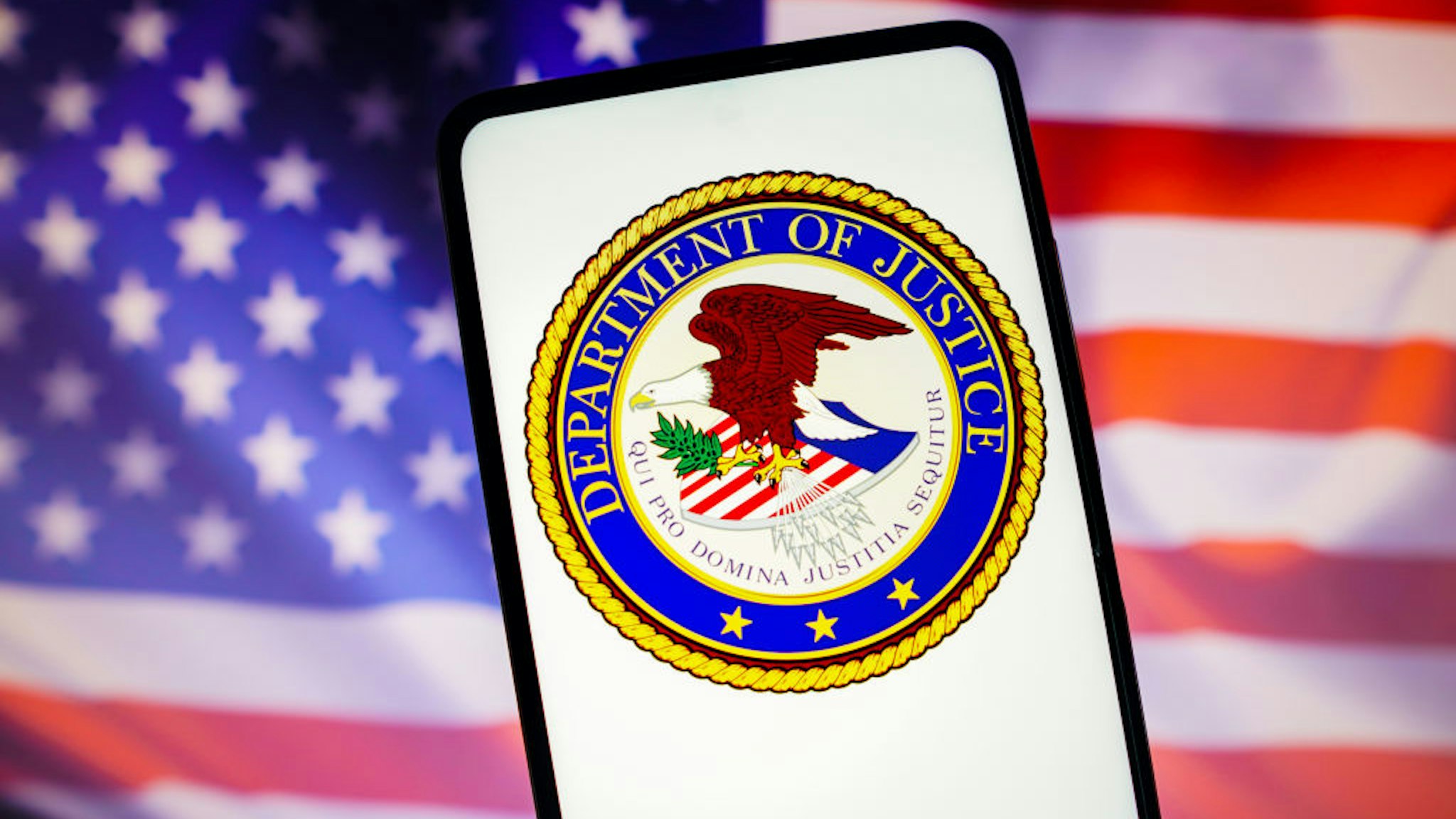 BRAZIL - 2022/11/13: In this photo illustration, the United States Department of Justice (DOJ) logo is displayed on a smartphone screen with a United States flag in the background. (Photo Illustration by Rafael Henrique/SOPA Images/LightRocket via Getty Images)