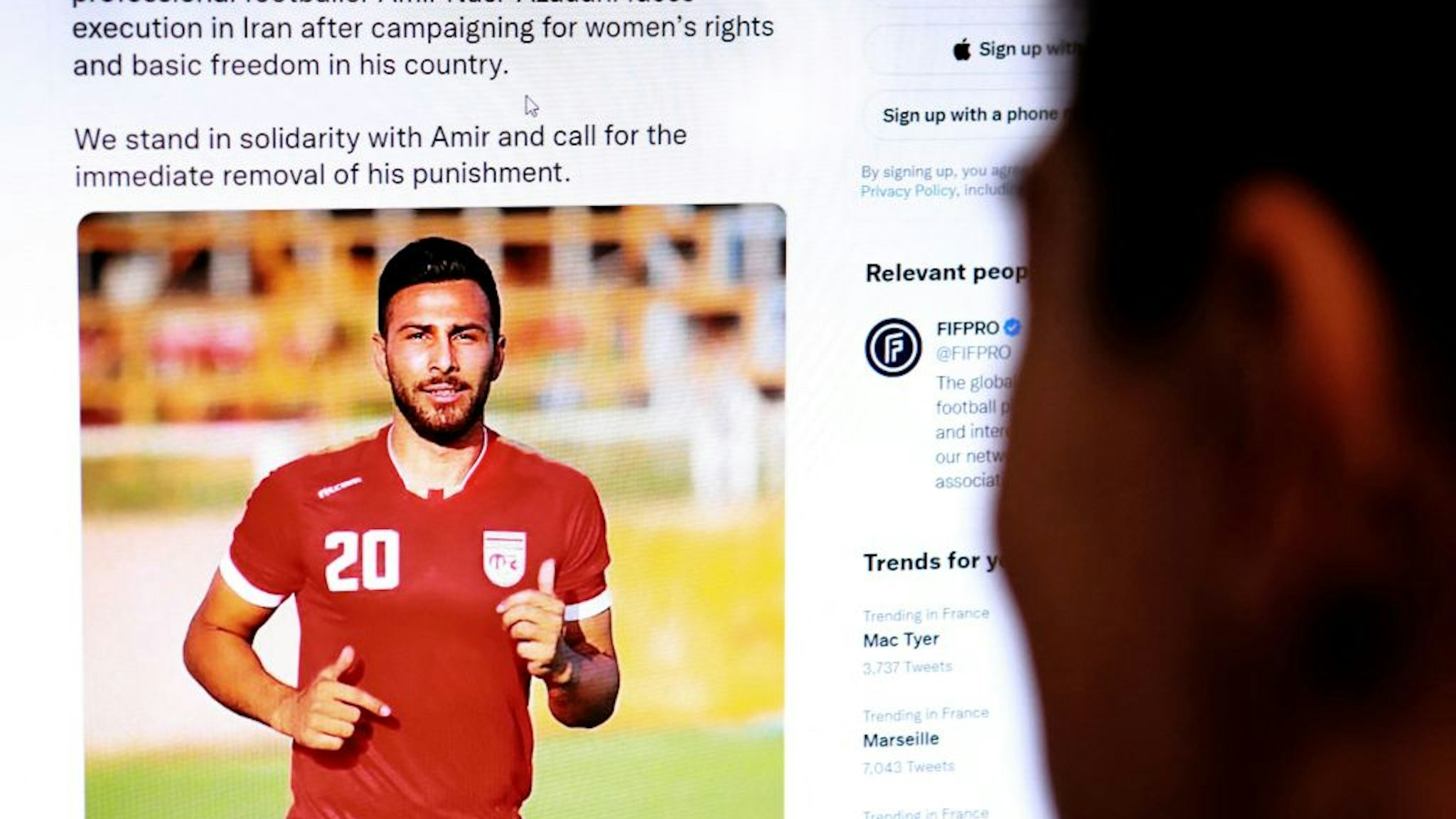 A person in the Cypriot capital Nicosia checks a tweet on December 13, 2022, by the International Federation of Professional Footballers (FIFPRO) regarding the reported risk of Iranian footballer Amir Nasr-Azadani being sentenced to death in connection with protests which have shaken the country for three months.