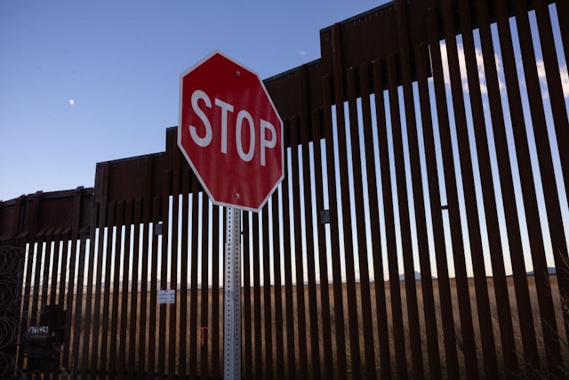 DOUGLAS, ARIZONA - NOVEMBER 03: A road sign stands near the U.S.-Mexico border fence on November 03, 2022 near Douglas, Arizona. In Arizona's Tucson Sector, some 75 percent of immigrants taken into custody by border officials try to evade capture, as opposed to other areas of the border where most of the immigrants are asylum seekers who turn themselves in for processing.