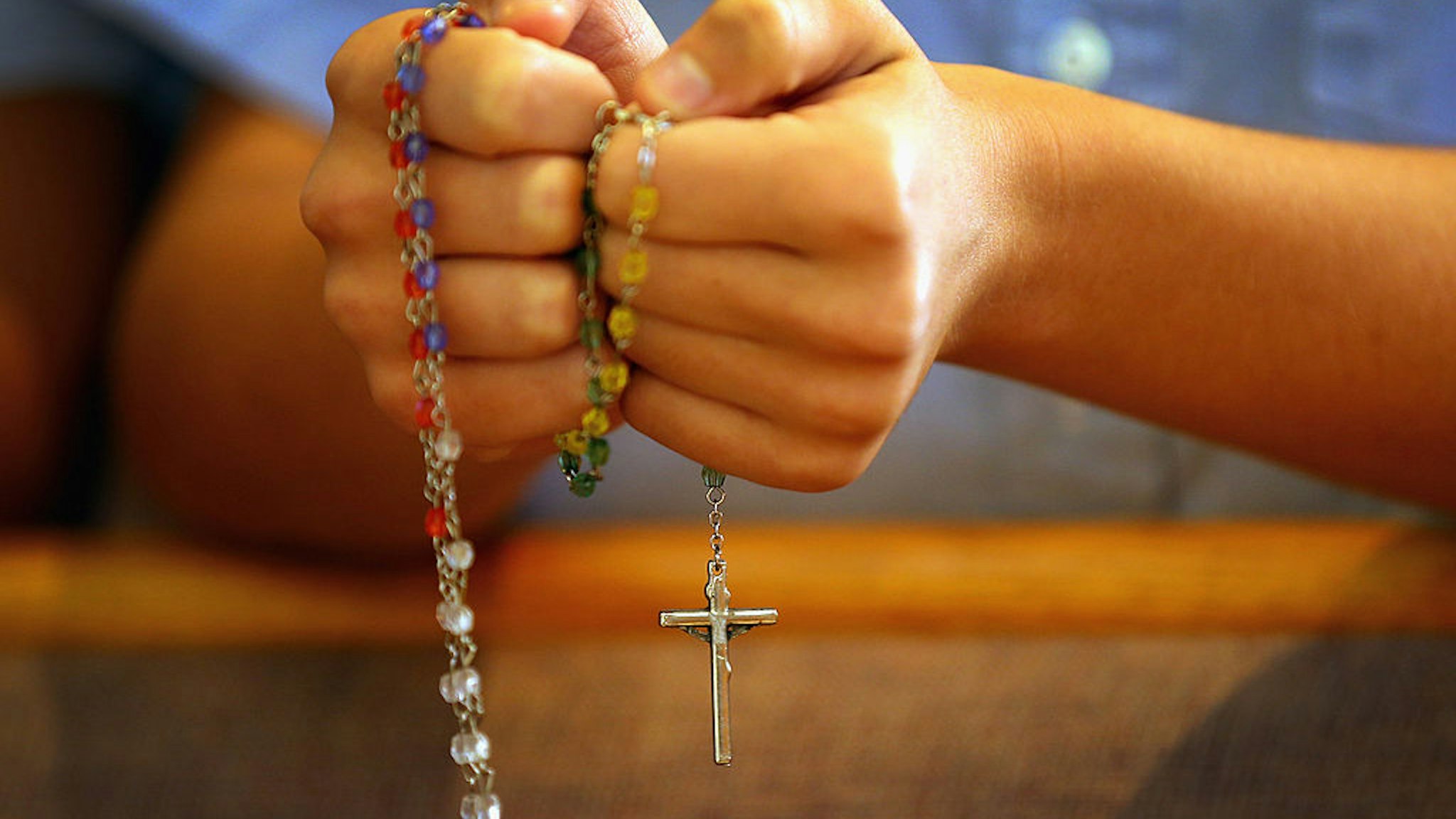 MIAMI, FL - DECEMBER 21: A child holds rosary beads as she prays during a service at St. Rose of Lima School, for the victims of the school shooting one week ago in Newtown, Connecticut on December 21, 2012 in Miami, Florida. Across the country people marked the one week point since the shooting at Sandy Hook Elementary School in Newtown, Connecticut that killed 26 people. (Photo by Joe Raedle/Getty Images)