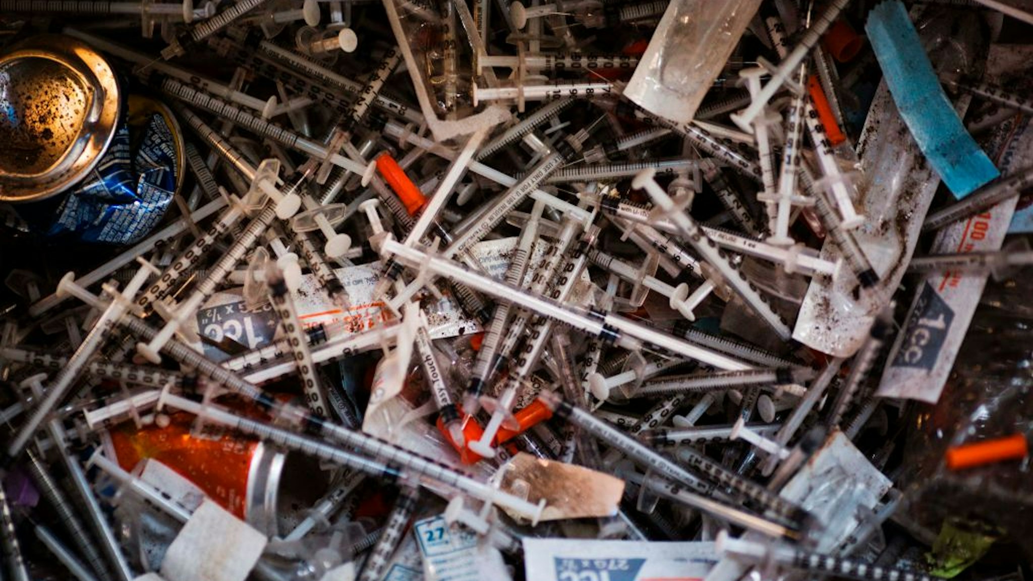 Discarded needles are seen at a heroin encampment in the Kensington neighborhood of Philadelphia, Pennsylvania, on April 7, 2017. In North Philadelphia, railroad gulch as it is knowen, is ground zero in Philadelphia?s opioid epidemic. Known by locals as El Campanento, the open air drug market and heroin encampment is built with the discarded materials from the gulch and populated by addicts seeking a hit of heroin to keep their dope sick, or withdrawal symptoms, at bay. In one area, near the 2nd Avenue overpass, empty syringe wrappers blanket the refuse like grass the used needles they once contained poking through like thistles. / AFP PHOTO / DOMINICK REUTER (Photo credit should read DOMINICK REUTER/AFP via Getty Images)