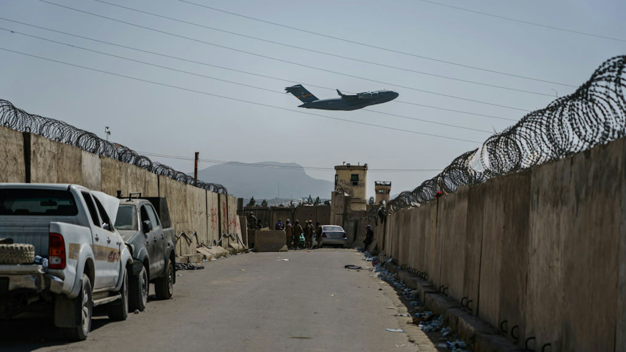 KABUL, AFGHANISTAN -- AUGUST 29, 2021: A C-17 Globemaster takes off as Taliban fighters secure the outer perimeter, alongside the American controlled side of of the Hamid Karzai International Airport in Kabul, Afghanistan, Sunday, Aug. 29, 2021. (MARCUS YAM / LOS ANGELES TIMES)