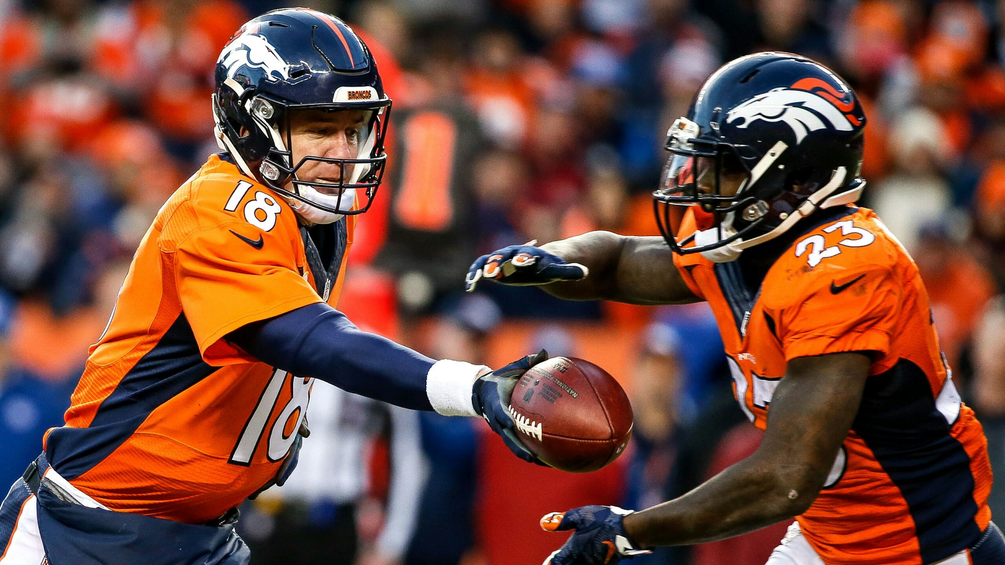 DENVER, CO - JANUARY 3: Quarterback Peyton Manning #18 of the Denver Broncos, who entered the game after Brock Osweiler #17 sustained an injury, hands off to running back Ronnie Hillman #23 at Sports Authority Field at Mile High on January 3, 2016 in Denver, Colorado.