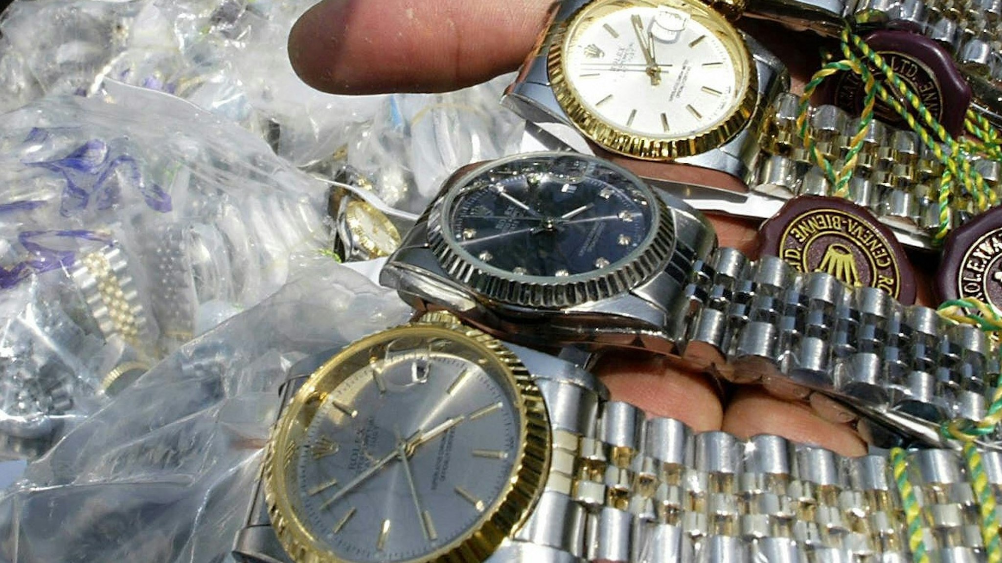 An unidentified Thai customs officer shows counterfeit Rolex watches confiscated in different raids during a display at the customs house in Bangkok, 11 March 2004.
