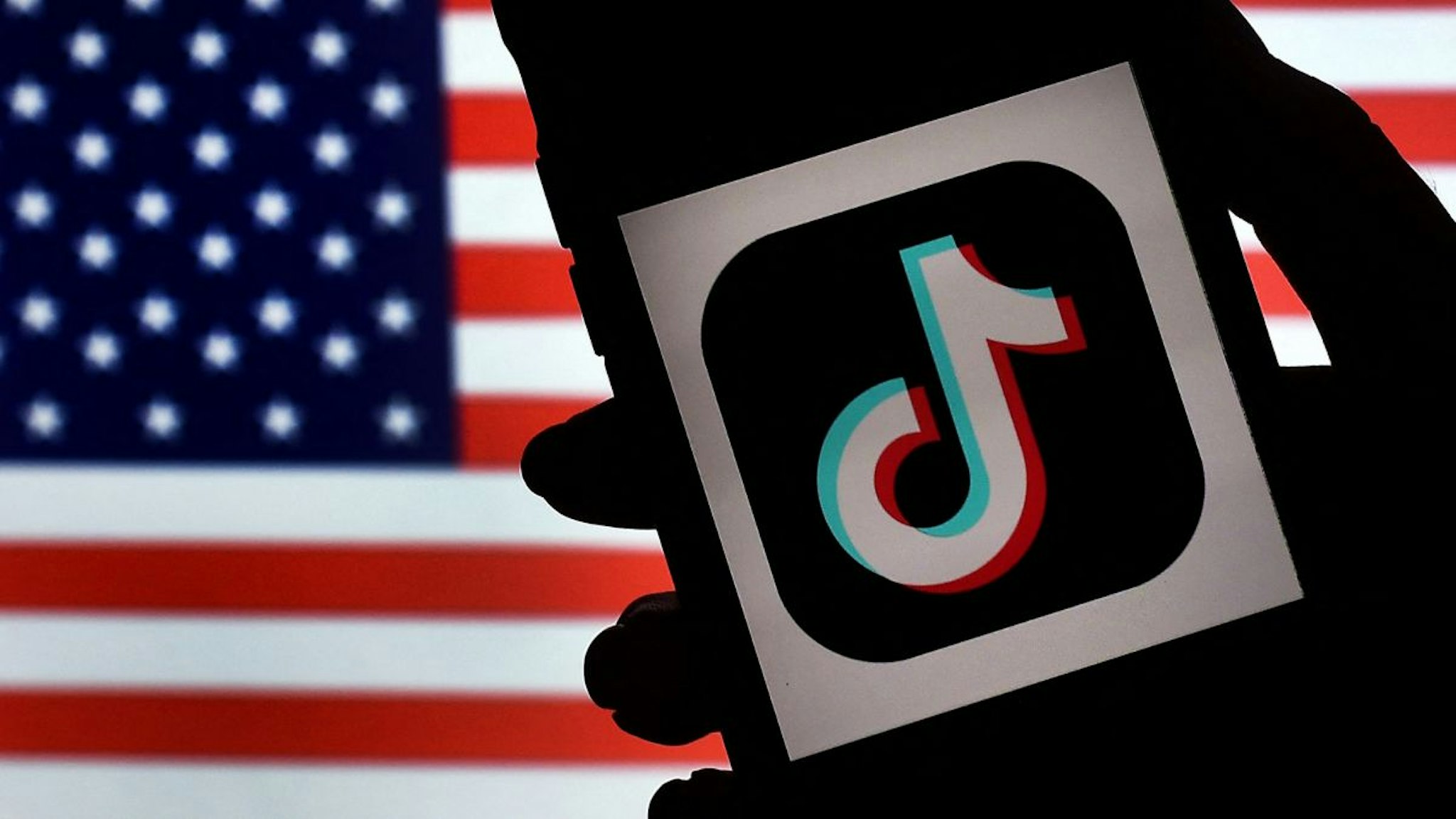 In this photo illustration, the social media application logo, TikTok is displayed on the screen of an iPhone on an American flag background on August 3, 2020 in Arlington, Virginia.