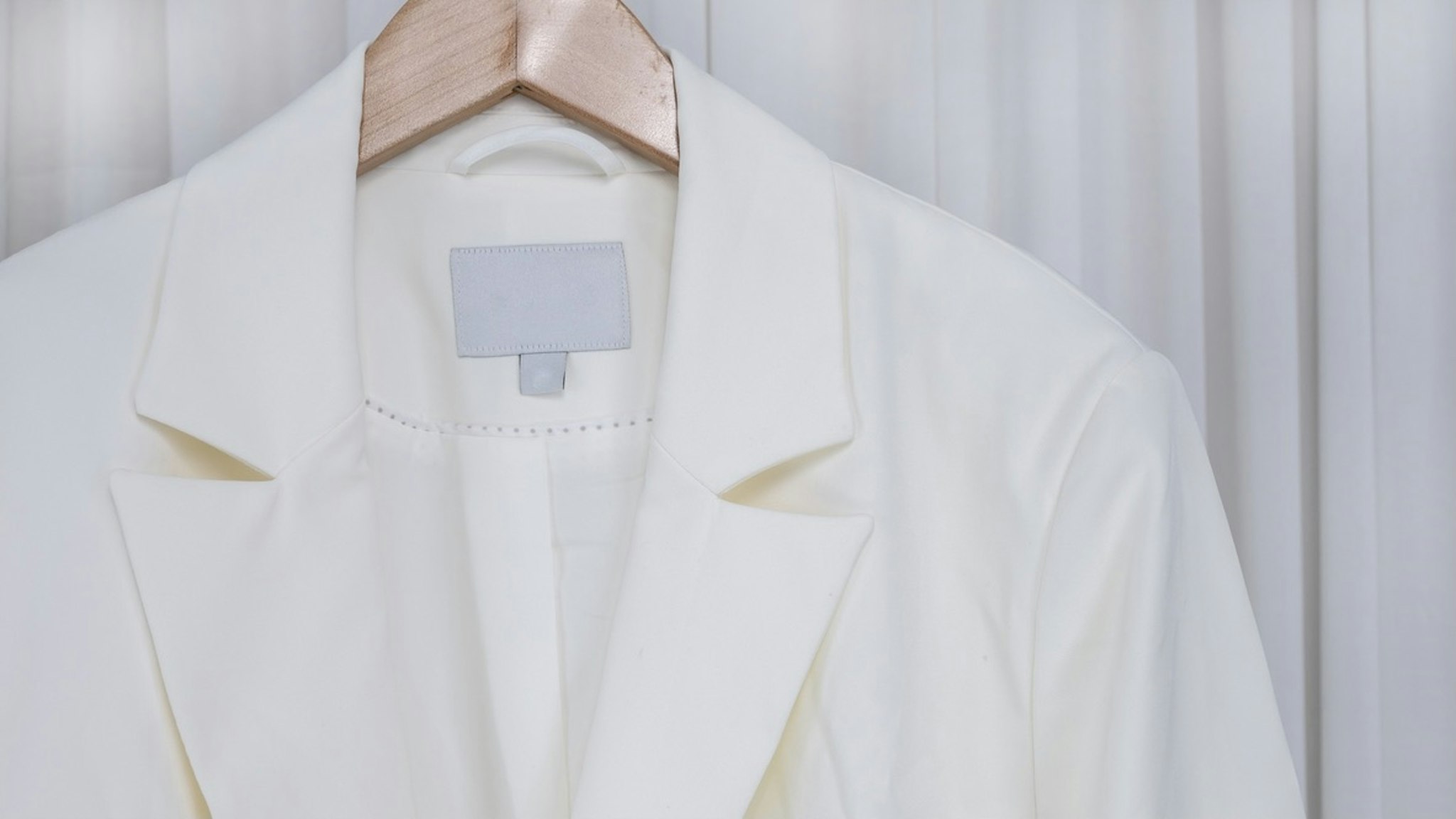 Close up white blazer - stock photo white blazer jacket Hanging On Rack At Home kampee patisena via Getty Images