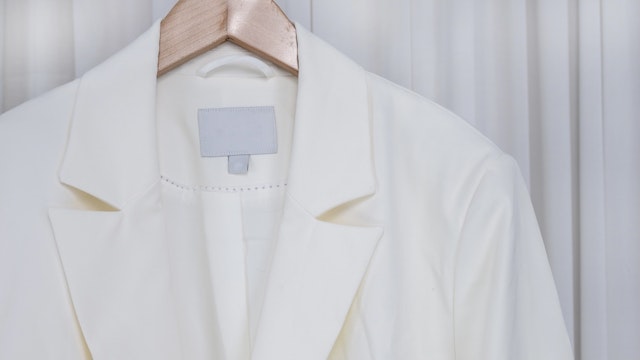 Close up white blazer - stock photo white blazer jacket Hanging On Rack At Home kampee patisena via Getty Images