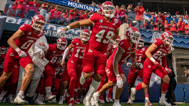 Elijah Gilliam #49, Steven Comstock #22, Mac Dalena #0, and the Bulldogs run out of the tunnel at the beginning of the LA Bowl game between Washington State Cougars and Fresno State Bulldogs at SoFi Stadium on December 17, 2022 in Los Angels, California.