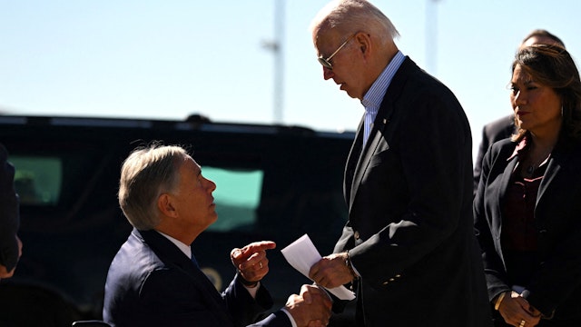 US President Joe Biden shakes hands with Texas Governor Greg Abbott after Abbott handed him a letter outlining the problems on the southern border upon arrival at El Paso International Airport in El Paso, Texas, on January 8, 2023.