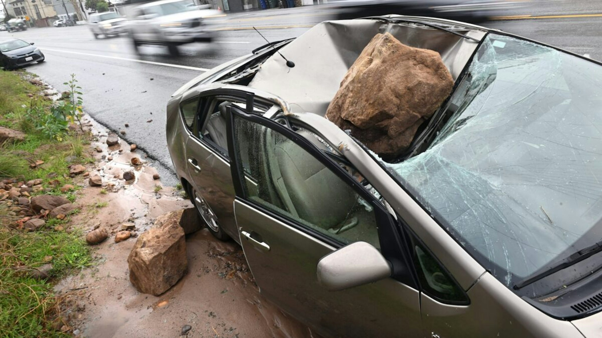 Malibu California January 10, 2023-A boulder crashed on top of a parked car along P.C.H. in Malibu Tuesday after a storm passed through.