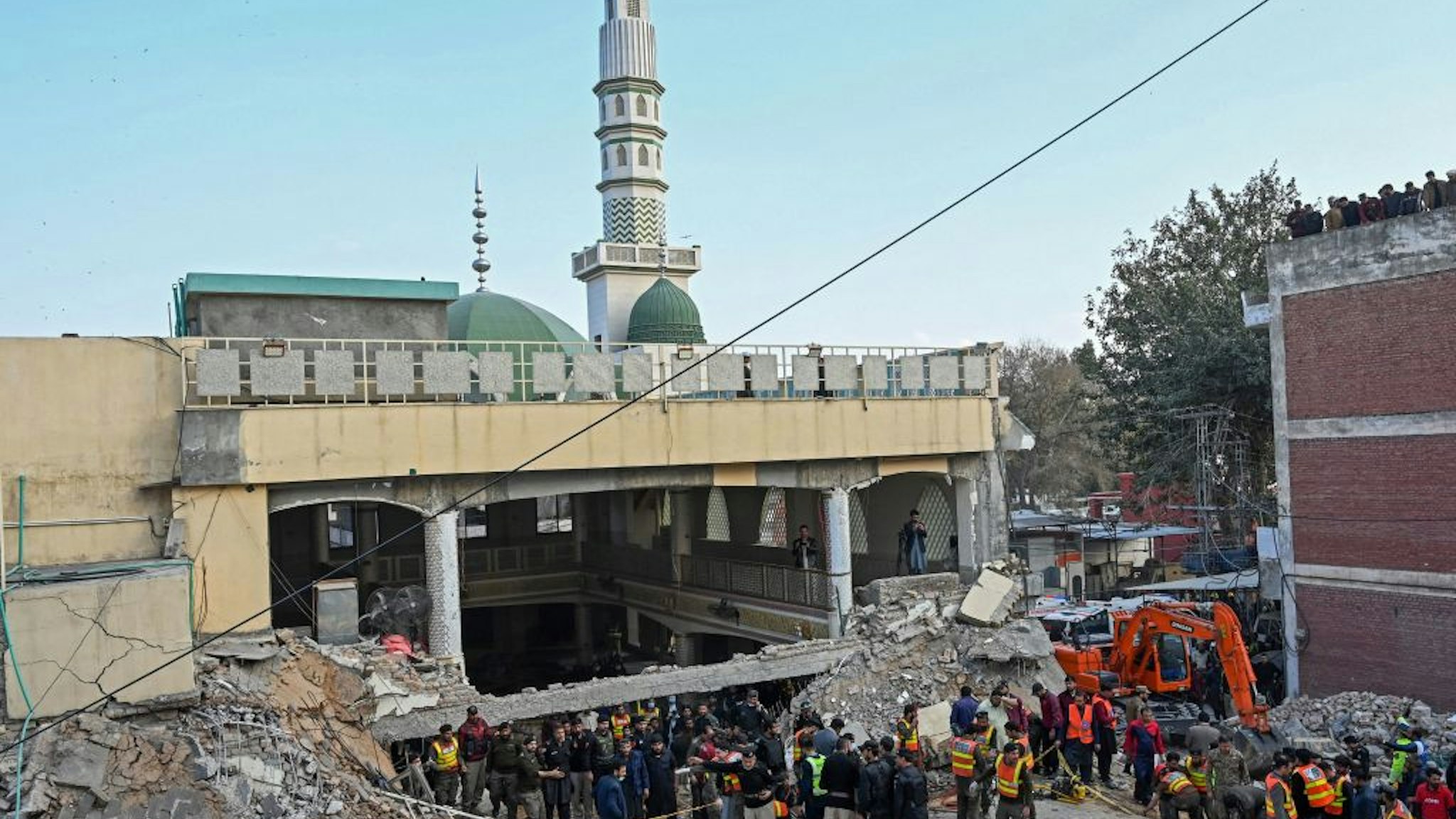 Security personnel and rescue workers prepare to search for the blast victims in the debris of a damaged mosque inside the police headquarters in Peshawar on January 30, 2023.