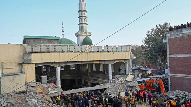 Security personnel and rescue workers prepare to search for the blast victims in the debris of a damaged mosque inside the police headquarters in Peshawar on January 30, 2023.