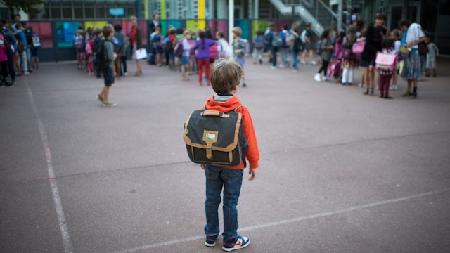 TOPSHOT - A pupil waits in the courtyard of a primary school on September 3, 2013 in Paris, on the first day of school. More than 12 million pupils went back to school today in France. AFP PHOTO / MARTIN BUREAU (Photo by MARTIN BUREAU / AFP) (Photo by MARTIN BUREAU/AFP via Getty Images)