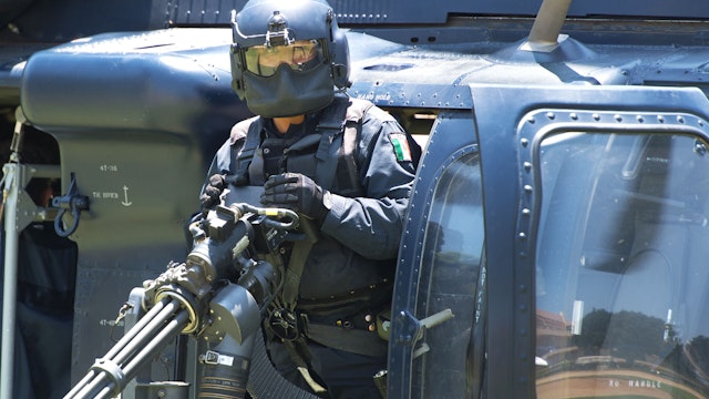 A Mexican Federal Police Officer checks his mini-gun aboard a Mexican Federal Police Black Hawk helicopter about to take off June 15, 2012, in San Jose del Cabo, Mexico, near the site of the G-20 Summit to be held June 18-20, 2012. There are 1000's of law enforcement officers rolling in to the Los Cabos area for the G-20 Summit with the world's largest country's leaders attending the international meeting of heads of state.