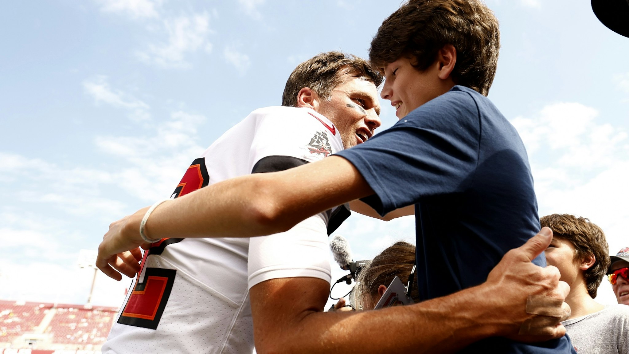 Tom Brady #12 of the Tampa Bay Buccaneers hugs his son John Edward Thomas Moynahan on the sidelines prior to the game against the Green Bay Packers at Raymond James Stadium on September 25, 2022 in Tampa, Florida.