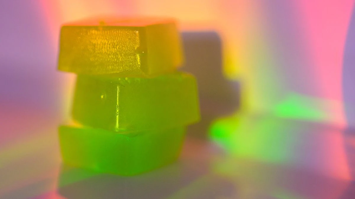 Stack of edible cannabis gummies in rainbow light - stock photo