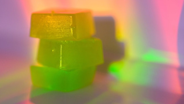 Stack of edible cannabis gummies in rainbow light - stock photo