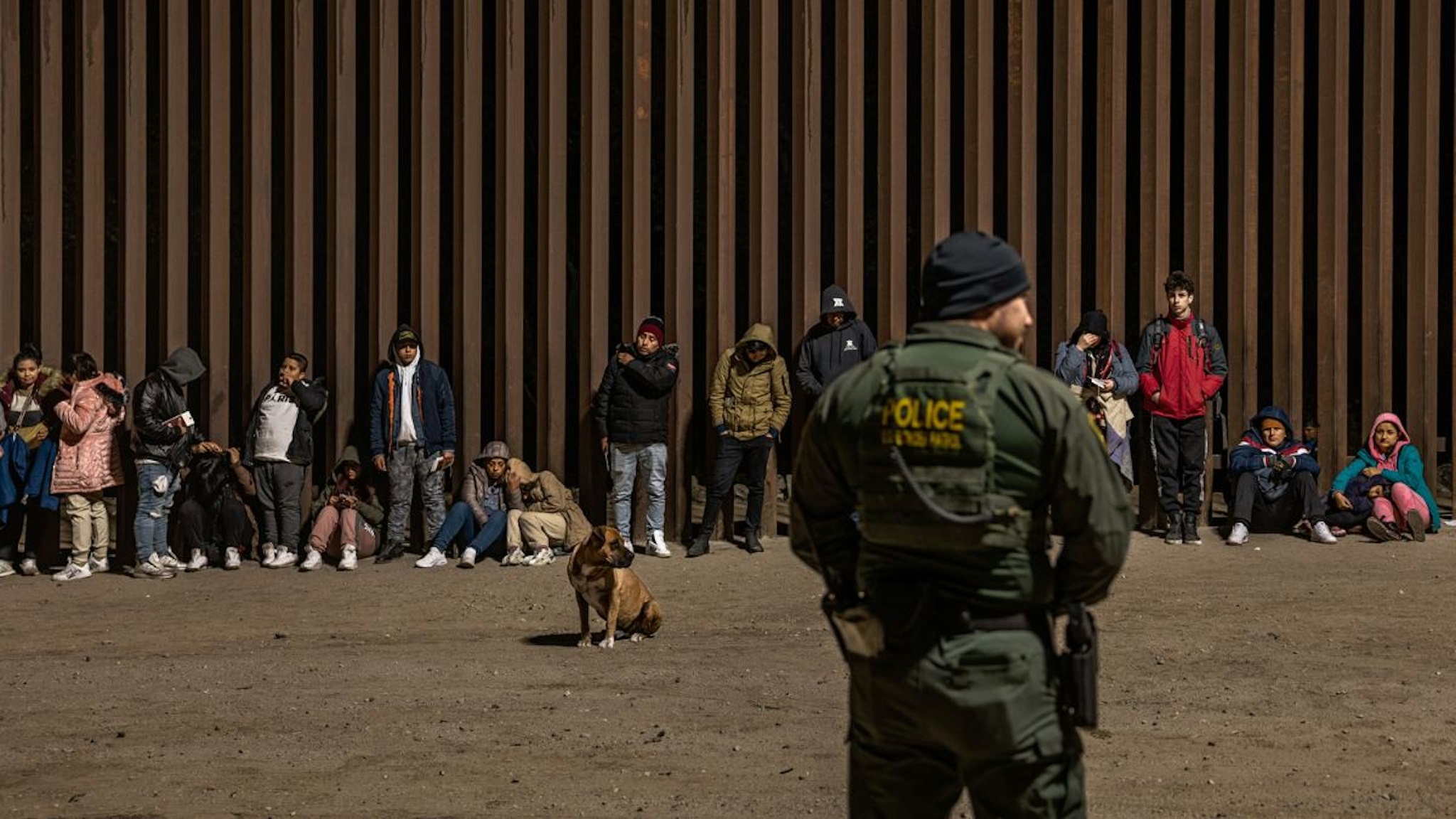 Immigrants wait to be processed by the U.S. Border Patrol after crossing the border from Mexico on December 30, 2022 in Yuma, Arizona.