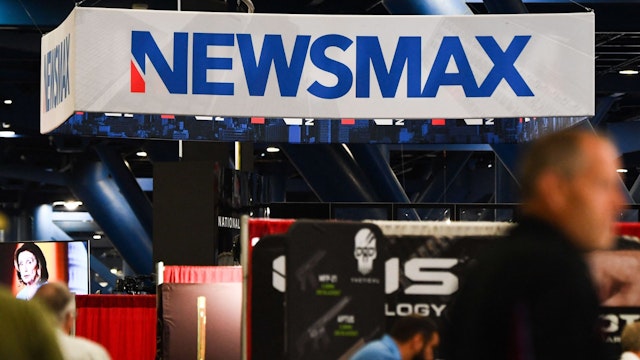 Signage for the Newsmax conservative television broadcasting network is displayed at a broadcast TV booth at the National Rifle Association (NRA) annual meeting at the George R. Brown Convention Center, in Houston, Texas on May 28, 2022. - America's powerful National Rifle Association kicked off a major convention in Houston Friday, days after the horrific massacre of children at a Texas elementary school, but a string of high-profile no-shows underscored deep unease at the timing of the gun lobby event.