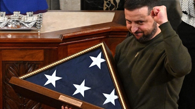 Ukraine's President Volodymyr Zelensky receives from US House Speaker Nancy Pelosi (D-CA) (L) a US national flag during his address to the US Congress at the US Capitol in Washington, DC on December 21, 2022