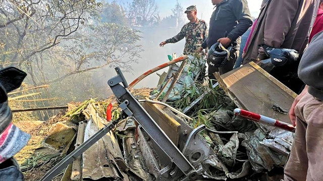 Rescuers gather at the site of a plane crash in Pokhara on January 15, 2023. - An aircraft with 72 people on board crashed in Nepal on January 15, Yeti Airlines and a local official said.