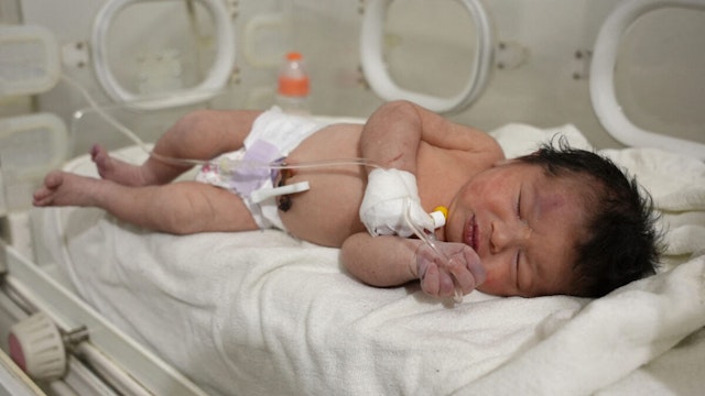 A newborn baby who was found still tied by her umbilical cord to her mother and pulled alive from the rubble of a home in northern Syria following a deadly earthquake, receives medical care at a clinic in Afrin, on February 7, 2023