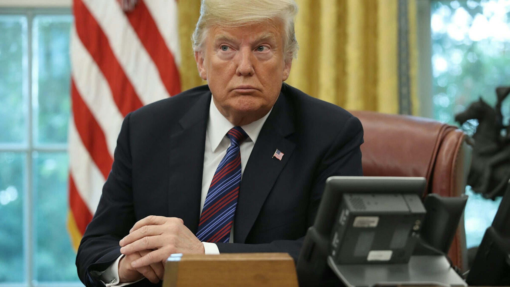U.S. President Donald Trump speaks on the telephone via speakerphone with Mexican President Enrique Pena Nieto in the Oval Office of the White House on August 27, 2018 in Washington, DC.