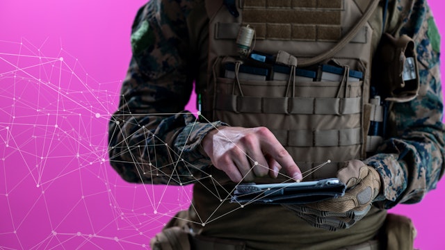 soldier using tablet computer hands closeup pnk background pixelated neural network concept