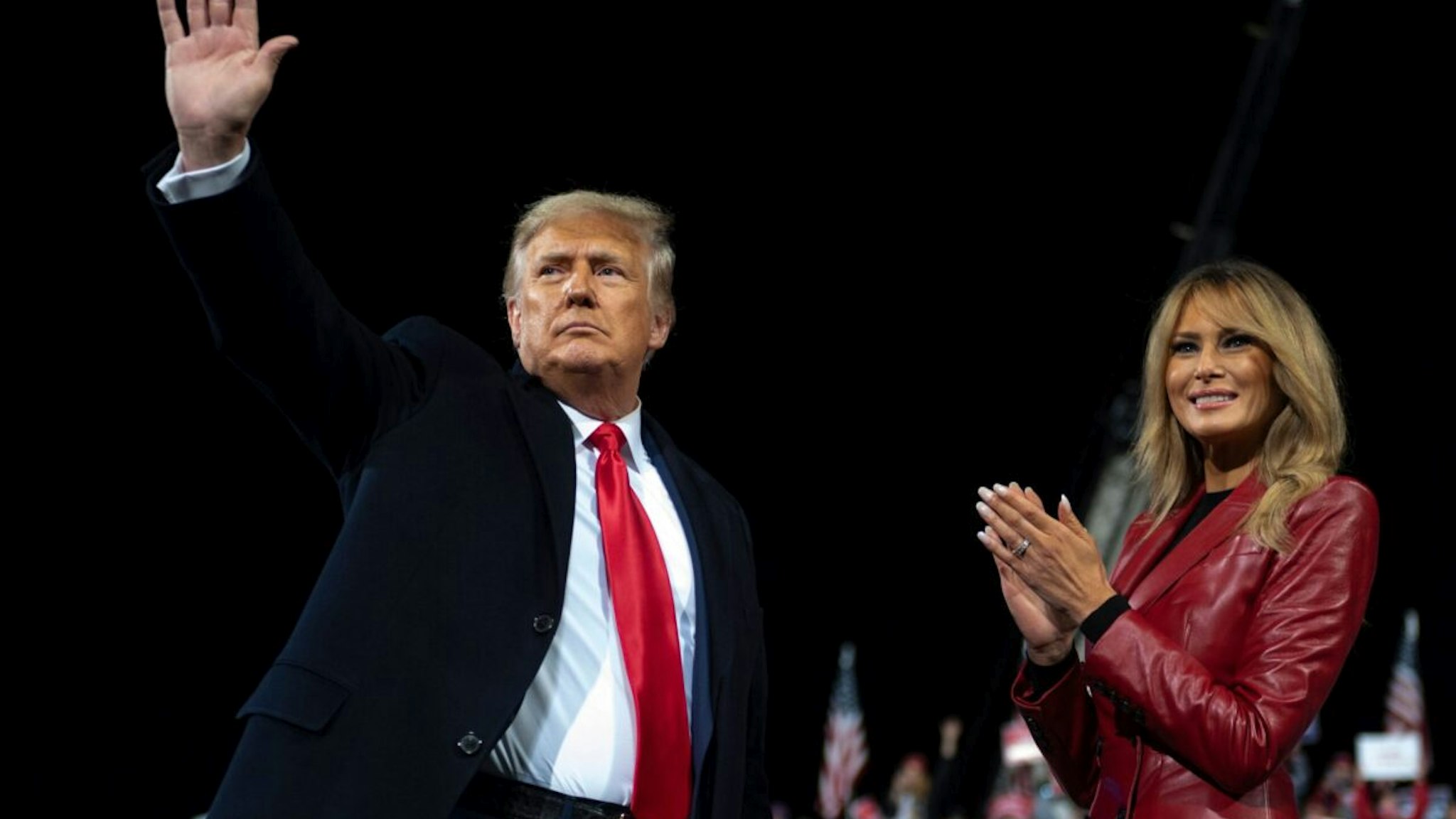 US President Donald Trump waves as he leaves the stage with First Lady Melania Trump at the end of a rally to support Republican Senate candidates at Valdosta Regional Airport in Valdosta, Georgia on December 5, 2020.