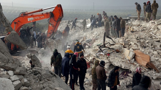 Residents and rescuers search for victims and survivors amidst the rubble of collapsed buildings following an earthquake in the village of Besnaya in Syria's rebel-held northwestern Idlib province on the border with Turkey, on February 6, 2022.