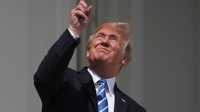 U.S. President Donald Trump looks up toward the Solar Eclipse on the Truman Balcony at the White House on August 21, 2017 in Washington, DC. Millions of people have flocked to areas of the U.S. that are in the "path of totality" in order to experience a total solar eclipse.