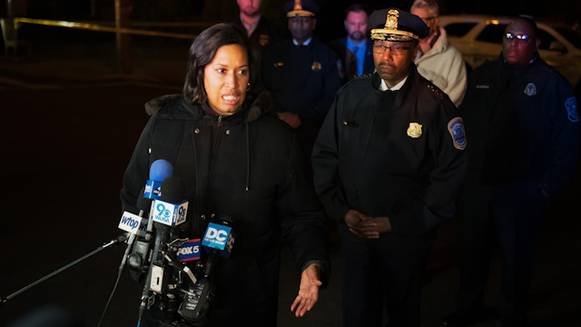 WASHINGTON, DC - JANUARY 11: DC Mayor Muriel Bowser speaks to reporters near the scene of a shooting on a metro bus at the corner of 14th and Sheridan St NW in the Brightwood neighborhood in Washington, DC on January 11, 2023. The shooting followed an altercation that occurred after several individuals boarded a bus and assaulted one individual. A gun was brandished and three people were shot; one adult male and one boy and one girl both under the age of 10. The individuals shot are reported to have serious but non life threatening injuries.