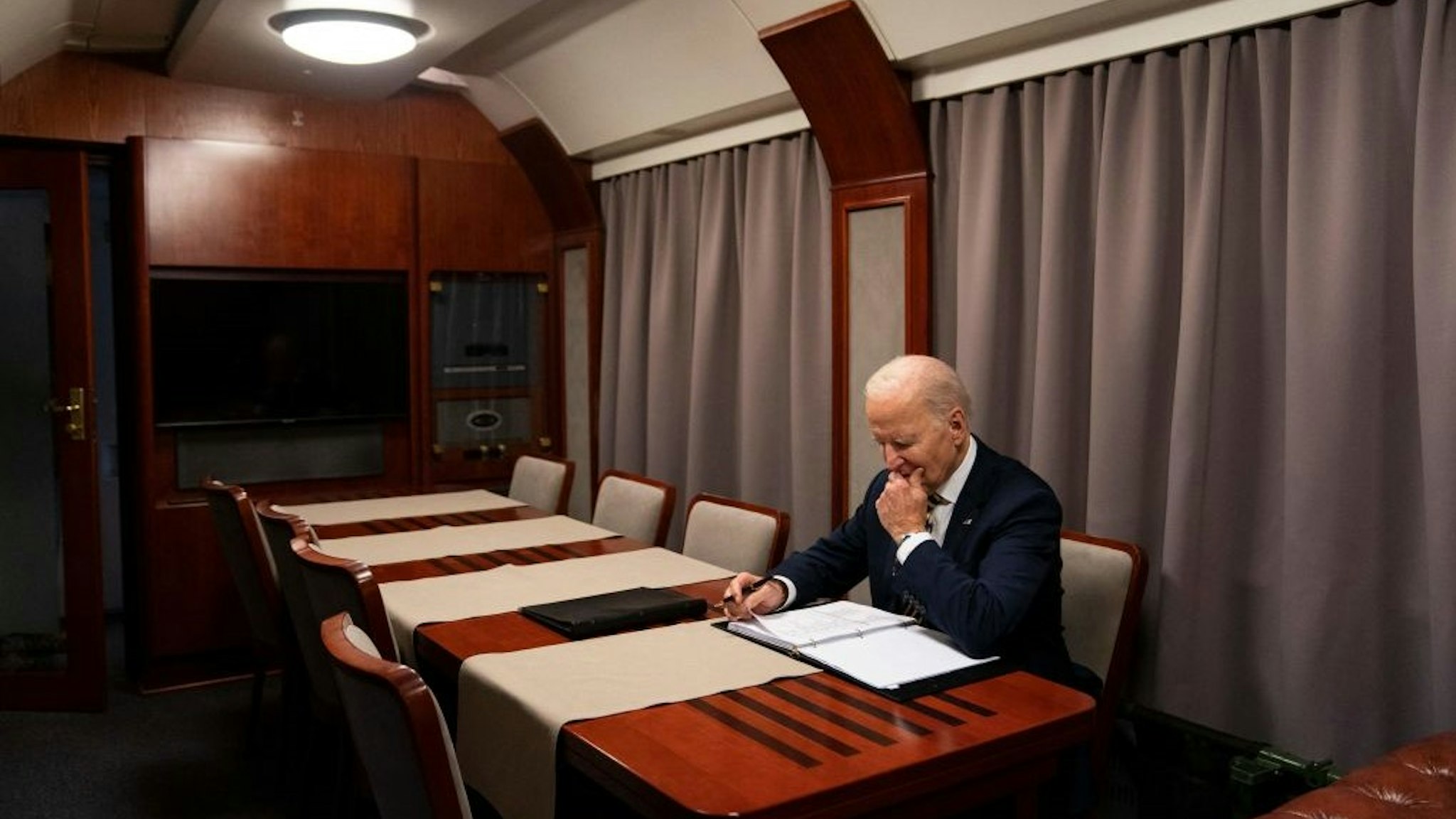 US President Joe Biden sits on a train as he goes over his speech marking the one-year anniversary of the war in Ukraine after a surprise visit to meet with Ukrainian President Volodymyr Zelenskyy, in Kyiv on February 20, 2023. (Photo by Evan Vucci / POOL / AFP) (Photo by