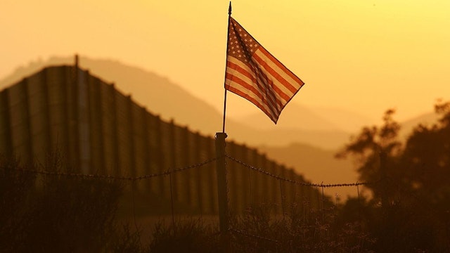 CAMPO, CA - OCTOBER 08: A U.S. flag put up by activists who oppose illegal immigration flies near the US-Mexico border fence in an area where they search for border crossers October 8, 2006 near Campo, California. The activists want the fence expanded into a fully-lit double-fenced barrier between the US (R) and Mexico. US Fish and Wildlife Service wardens and environmentalists warn that a proposed plan by US lawmakers to construct 700 miles of double fencing along the 2,000-mile US-Mexico border, in an attempt to wall-out illegal immigrants, would also harm rare wildlife. Wildlife experts say cactus-pollinating insects would fly around fence lights, birds that migrate by starlight in the desert wilderness would be confused, and large mammals such as jaguars, Mexican wolves, Sonoran pronghorn antelope, and desert bighorn sheep would be blocked from migrating across the international border, from California to Texas. (Photo by David McNew/Getty Images)