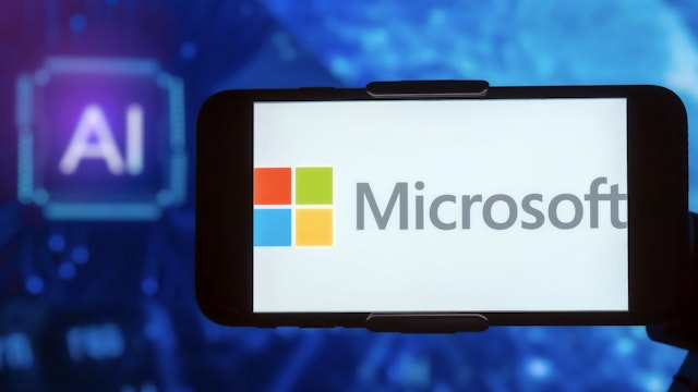 NDIA - 2023/02/17: In this photo illustration, the logo of Microsoft is seen displayed on a mobile phone screen with AI (artificial intelligence) written in the background.