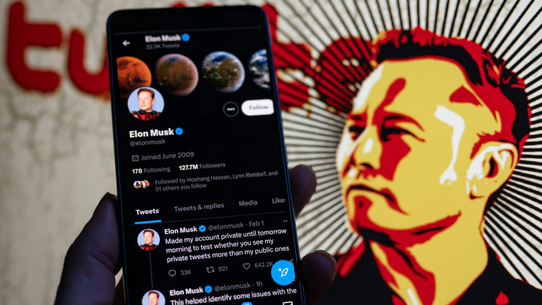 Elon Musk Twitter account private page seen on Mobile with Elon Musk in the background on screen.