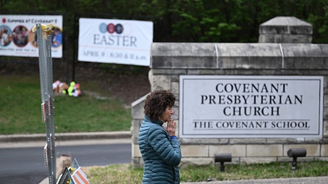 Robin Wolfenden prays at a makeshift memorial for victims outside the Covenant School building at the Covenant Presbyterian Church following a shooting, in Nashville, Tennessee, on March 28, 2023.