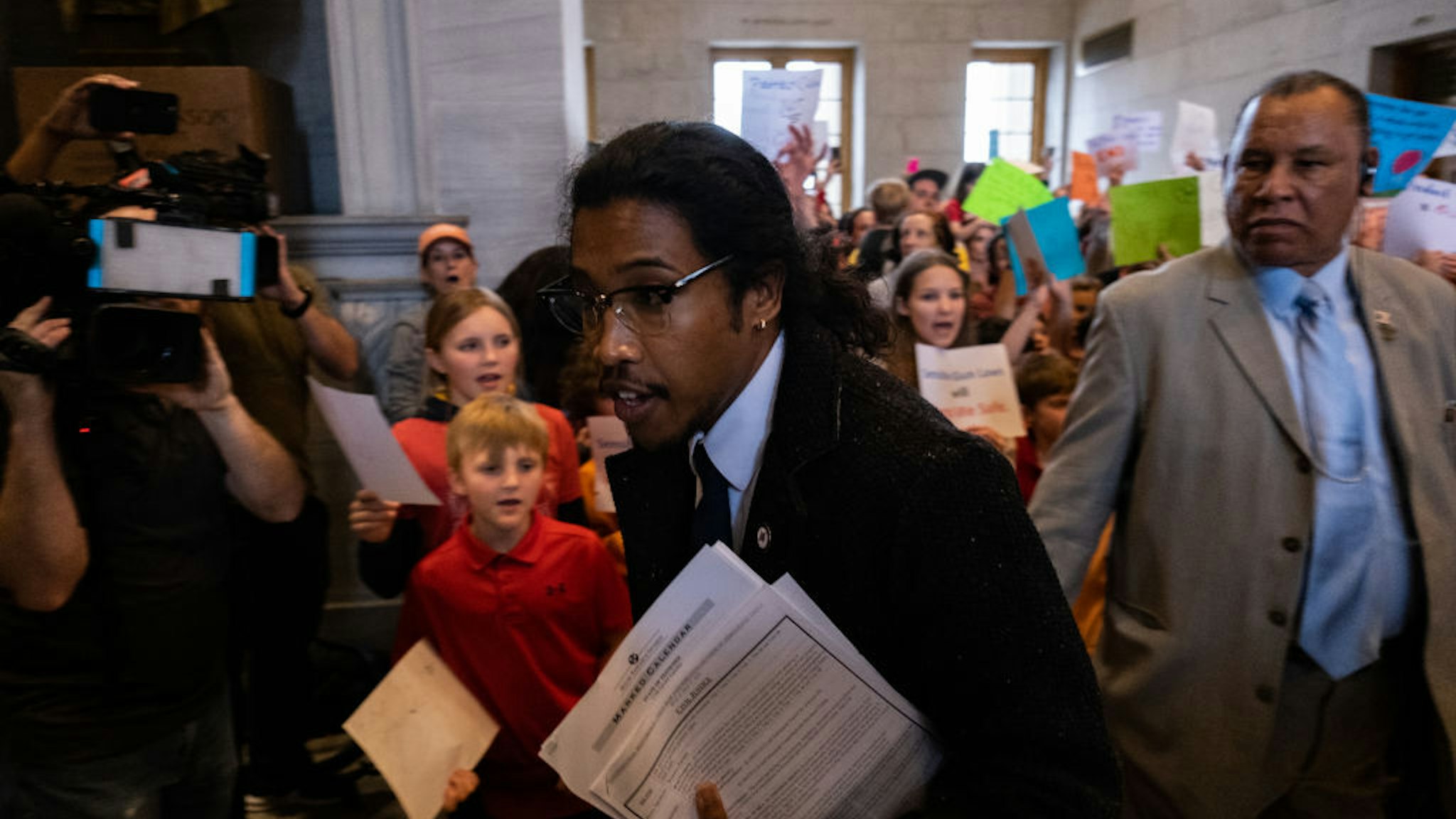 NASHVILLE, TN - APRIL 03: Democratic state Rep. Justin Jones enters the house chamber ahead of session as protesters chant demanding action for gun reform laws in the state at the Tennessee State Capitol on April 3, 2023 in Nashville, Tennessee. A 28-year-old former student of the private Covenant School in Nashville, wielding a handgun and two AR-style weapons, shot and killed three 9-year-old students and three adults before being killed by responding police officers on March 27.