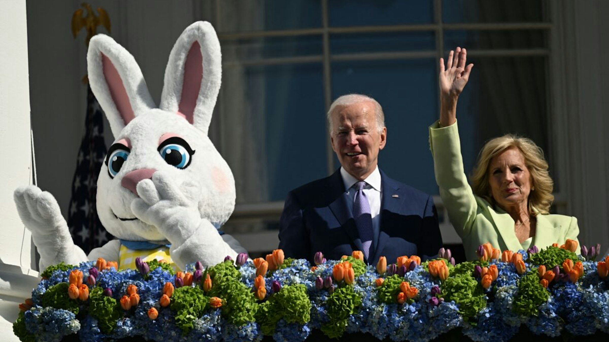 US President Joe Biden, alongside First Lady Jill Biden and the Easter Bunny (L), waves after speaking at the annual Easter Egg Roll on the South Lawn of the White House in Washington, DC, on April 10, 2023.