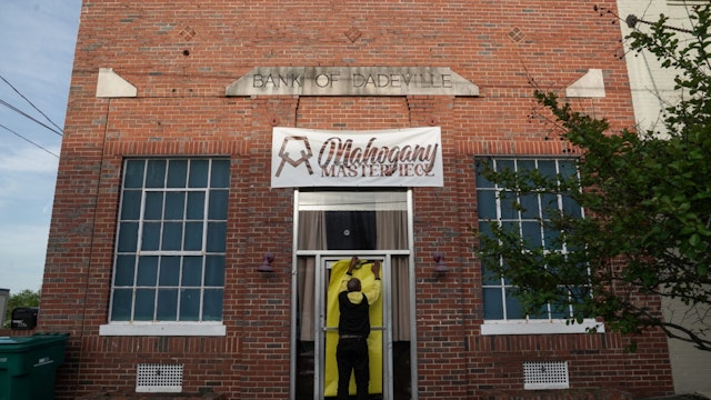 Norman Brooks covers the door of the Mahogany Masterpiece dance studio, the scene of last night's deadly mass shooting, on April 16, 2023 in Dadeville, Alabama.