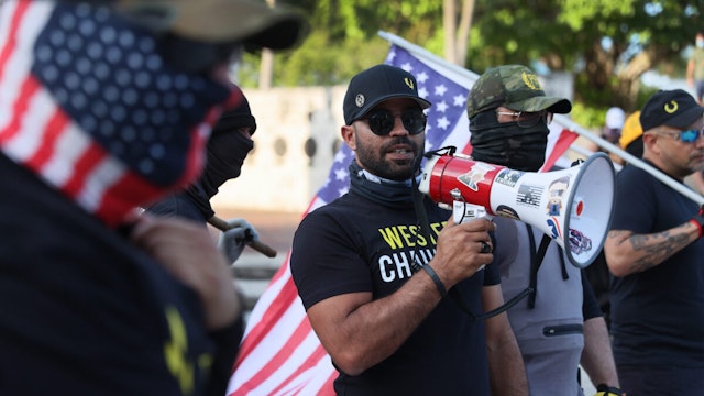 Enrique Tarrio (C), leader of the Proud Boys, uses a megaphone while counter-protesting people gathered at the Torch of Friendship to commemorate the one year anniversary of the killing of George Floyd on May 25, 2021 in Miami, Florida.