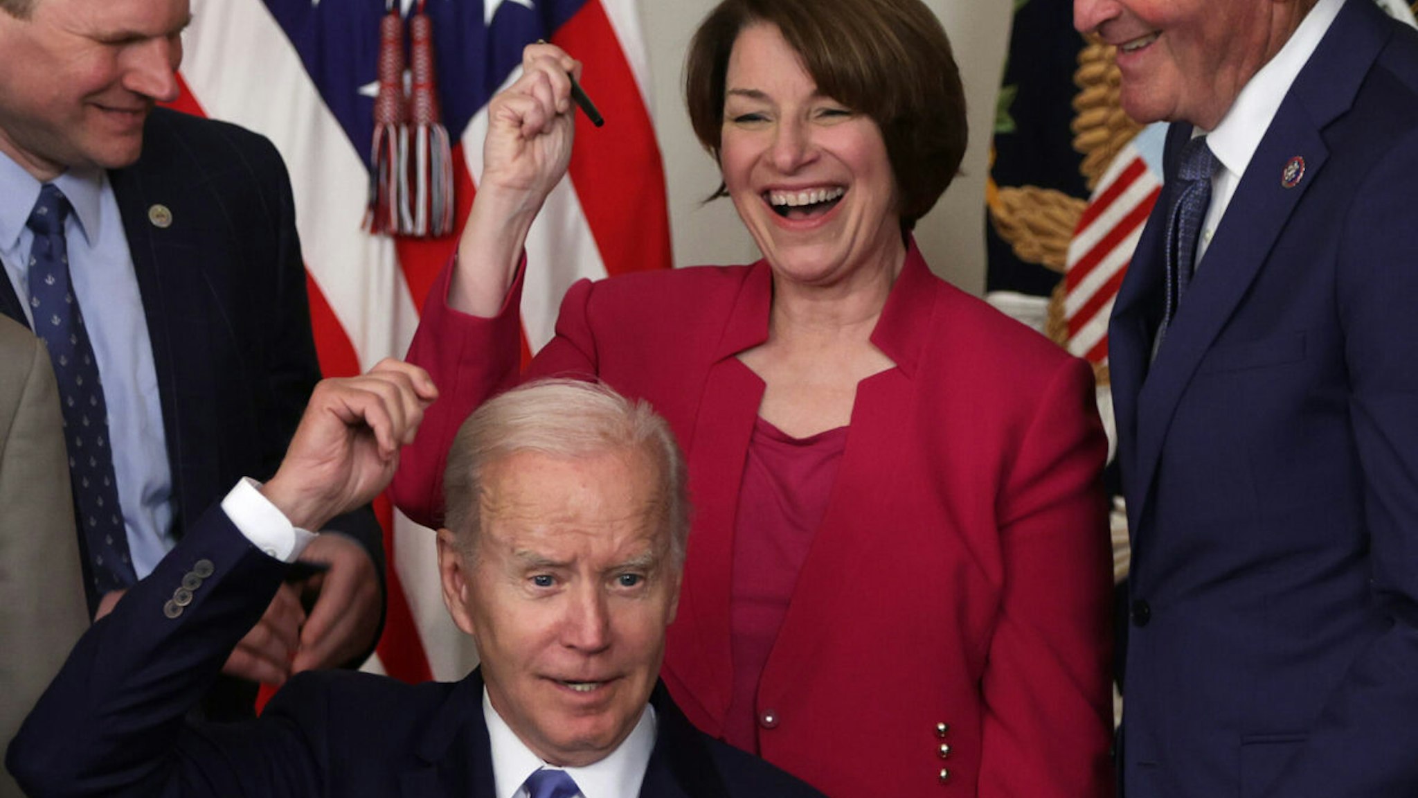 U.S. President Joe Biden gives Sen. Amy Klobuchar (D-MN) (2nd R) his signing pen as Rep. John Garamendi (D-CA) (R) looks on during a bill signing event at the State Dining Room of the White House June 16, 2022 in Washington, DC.