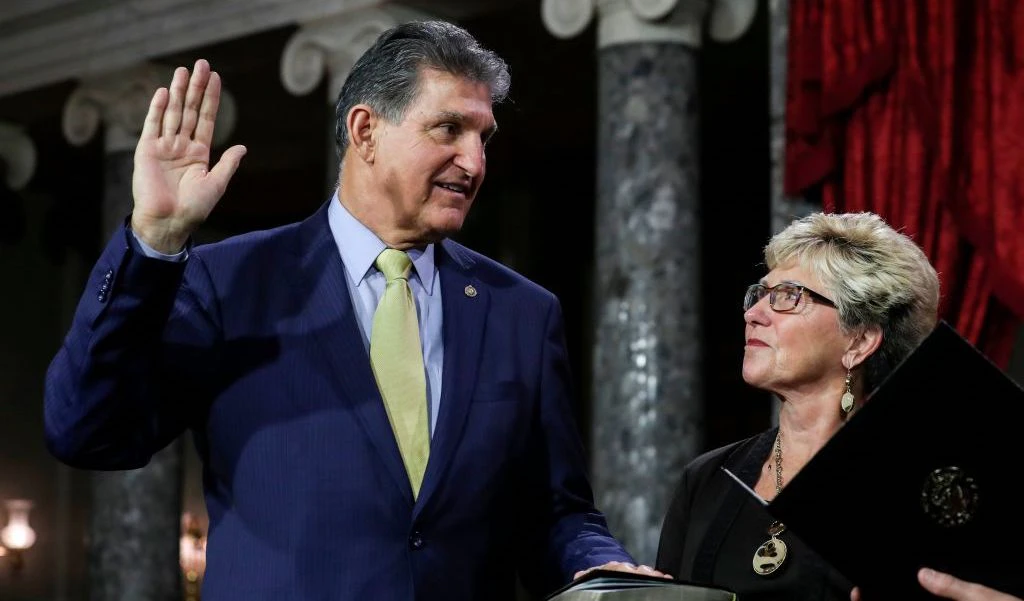 US Senator from West Virginia (D) Joe Manchin III is flanked his wife Gayle as he is sworn in by Vice President Mike Pence (out of frame) during the swearing-in re-enactments for recently elected senators in the Old Senate Chamber on Capitol Hill in Washington, DC January 3, 2019. (Photo by Alex EDELMAN / AFP) (Photo credit should read ALEX EDELMAN/AFP via Getty Images)