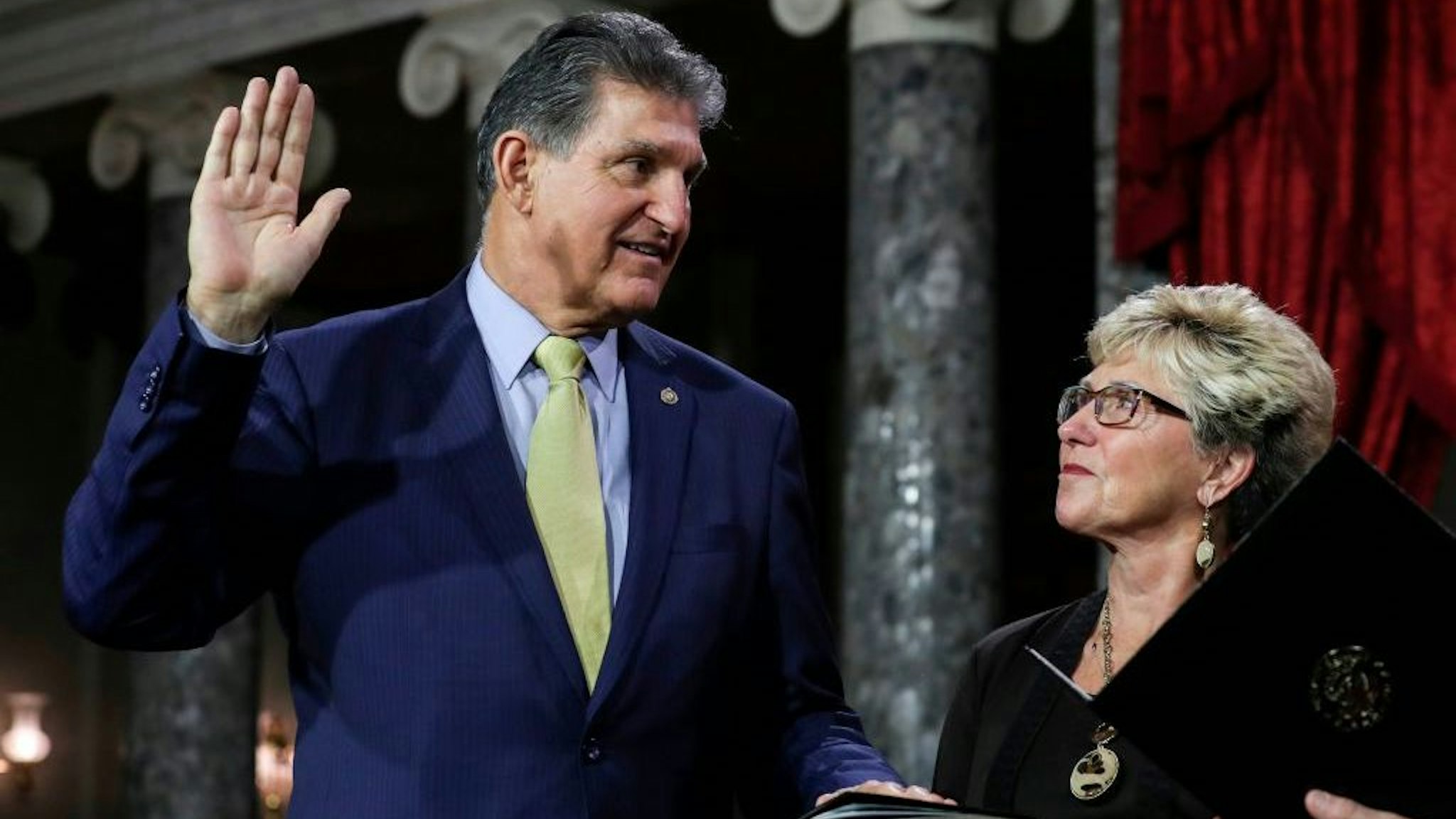 US Senator from West Virginia (D) Joe Manchin III is flanked his wife Gayle as he is sworn in by Vice President Mike Pence (out of frame) during the swearing-in re-enactments for recently elected senators in the Old Senate Chamber on Capitol Hill in Washington, DC January 3, 2019. (Photo by Alex EDELMAN / AFP) (Photo credit should read ALEX EDELMAN/AFP via Getty Images)