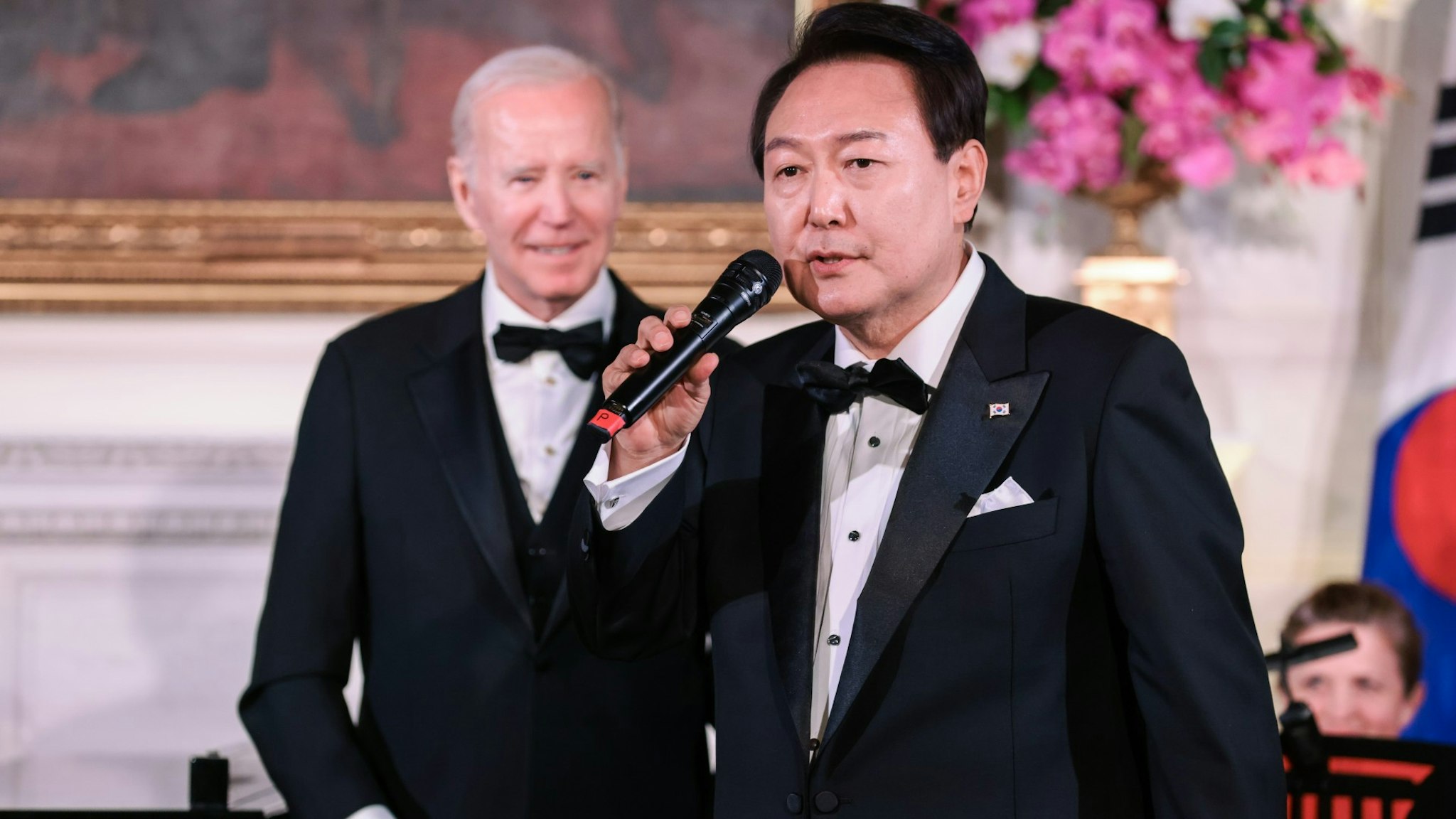 Yoon Suk Yeol, South Korea's president, right, sings during a state dinner with US President Joe Biden, left, at the White House in Washington, DC, US, on Wednesday, April 26, 2023.