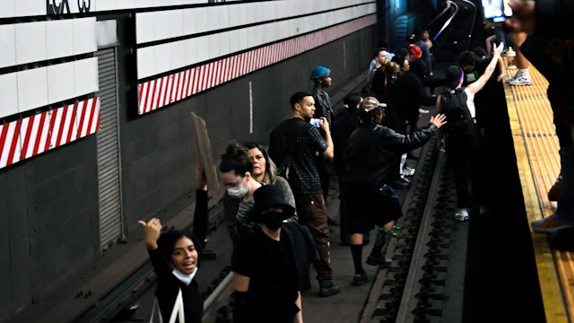 NEW YORK, NEW YORK - MAY 06: Protesters stand on the trains tracks at the Lexington Ave/63rd Street subway station as a train approaches the station during a "Justice for Jordan Neely" protest that began outside the Broadway-Lafayette station on May 06, 2023 in New York City. More than 15 people were arrested throughout the day with most arrests happening in the subway station after protestors stopped a train from leaving the station and walked on the subway tracks. According to police and a witness account, Neely, who was 30 years old and residing in a shelter, died after being placed in a chokehold by a 24-year-old man on a subway train in New York City on Monday. Increasingly, activists are calling for the man who used the chokehold on Neely to be apprehended.