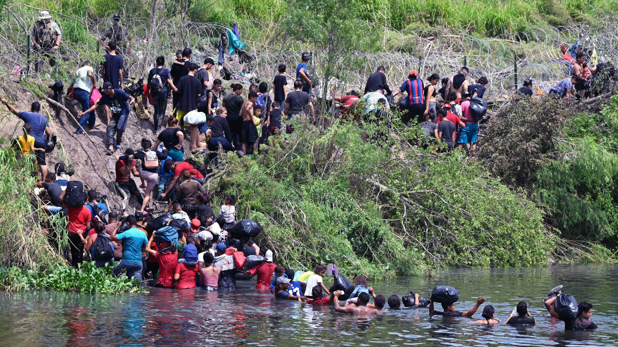 TOPSHOT - Migrants cross the Rio Grande River as they try to get to the US, as seen from Matamoros, state of Tamaulipas, Mexico, on May 11, 2023. Pandemic-era controls barring migrants from claiming US asylum expire Thursday night amid fears of chaos at the Mexican border, with a tough new policy spelling uncertainty for thousands seeking refuge in America. The White House warned that beginning Friday, anyone entering the United States illicitly will face a lengthy ban and possible criminal charges.