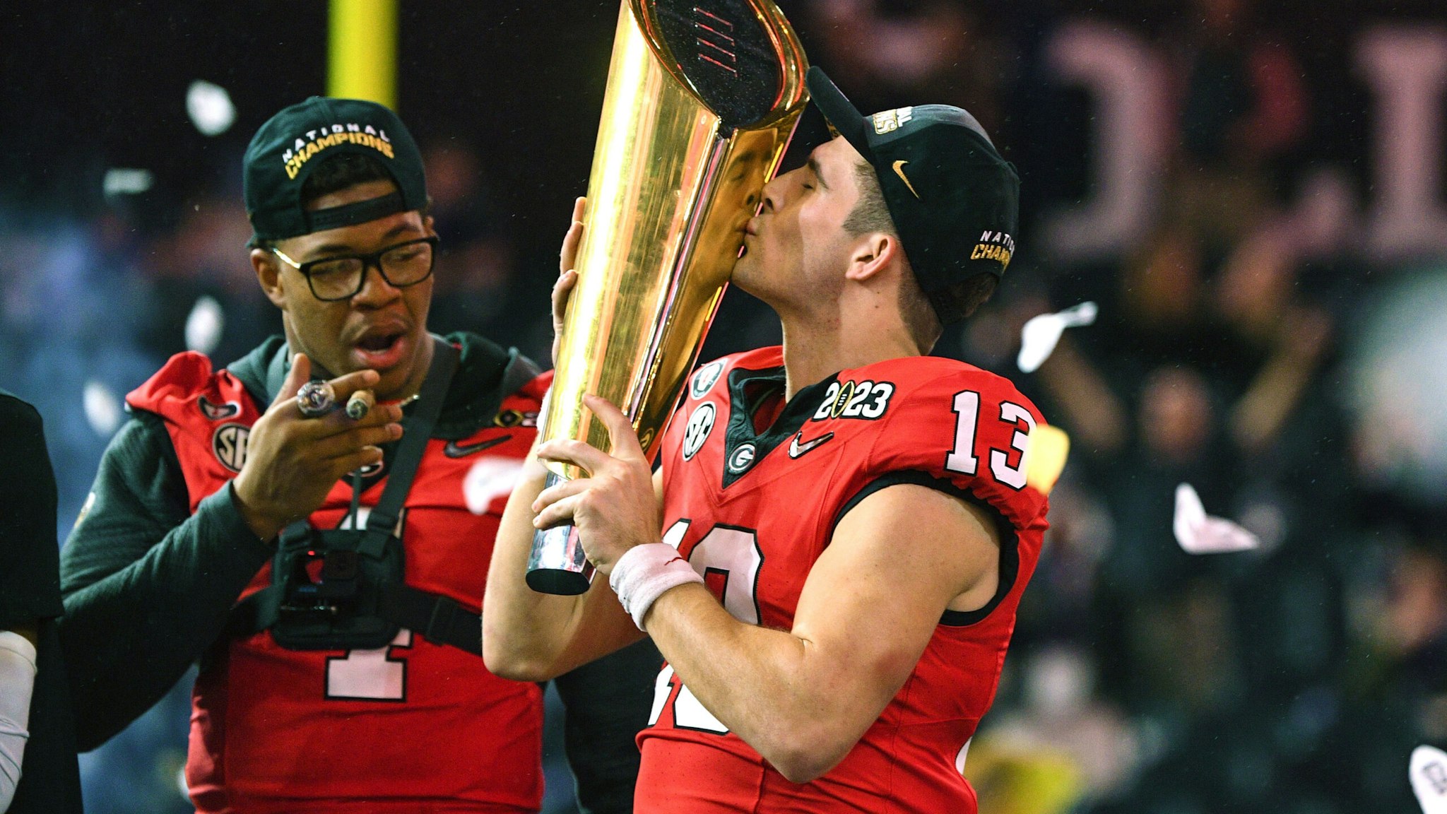 INGLEWOOD, CA - JANUARY 09: Georgia Bulldogs quarterback Stetson Bennett (13) kisses the championship trophy after the Georgia Bulldogs defeated the TCU Horned Frogs in the College Football Playoff National Championship game on January 9, 2023, at SoFi Stadium in Inglewood, CA.