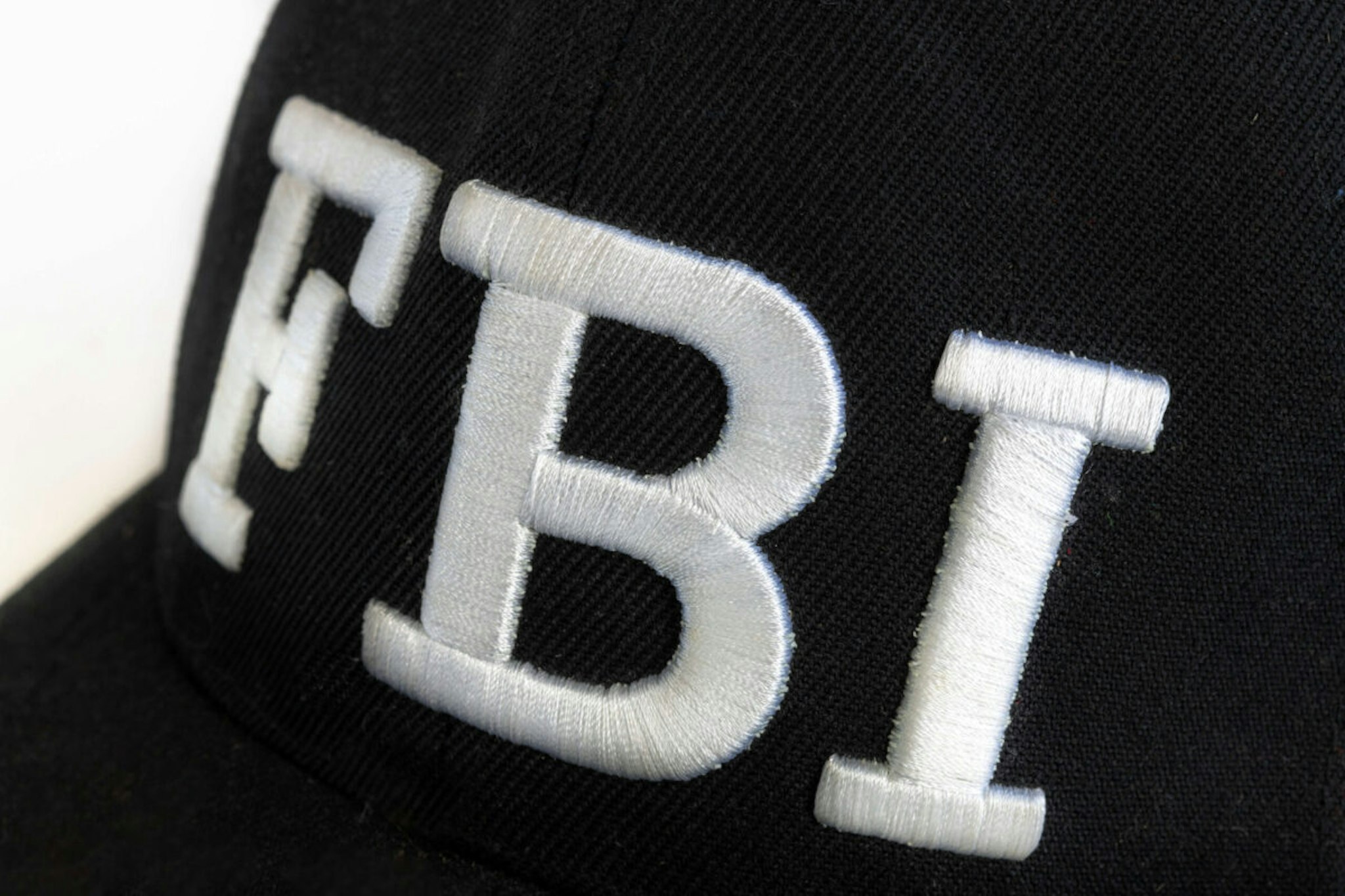 Close up of the FBI logo on a black cap. The text stands for Federal Bureau of Investigations.