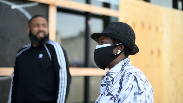 Councilwoman Cherelle Parker (R) talks to store manager Mario Lawrence at a vandalized and looted Villa sneaker store in the Mt Airy/Wadsworth sections of Northwest Philadelphia, PA on June 1, 2020. On Monday morning National Guard troops arrived to assist policing the city after two days of unrest and protests over the death of George Floyd.